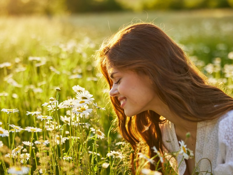 Frau die an Blumen riecht im Sommer