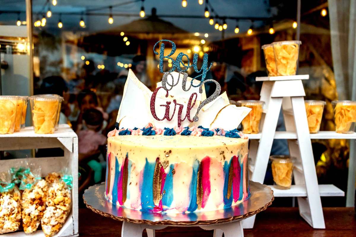 Kuchen im Schaufenster für eine Gender Reveal Party, mit einem Schild 'Boy or Girl' obendrauf.