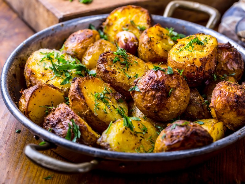 Eine Schale Knoblauchkartoffeln mit Zitrone und Petersilie