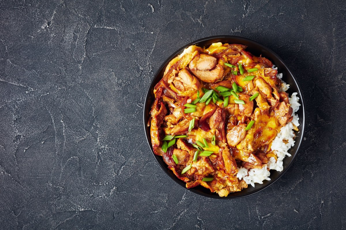 Eine Schüssel Oyakodon auf einem grauen Hintergrund.