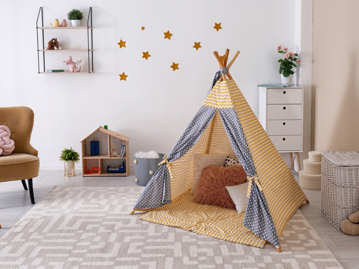 Kleines Kinderzimmer eingerichtet mit einem Zelt, Möbeln und Dekoration