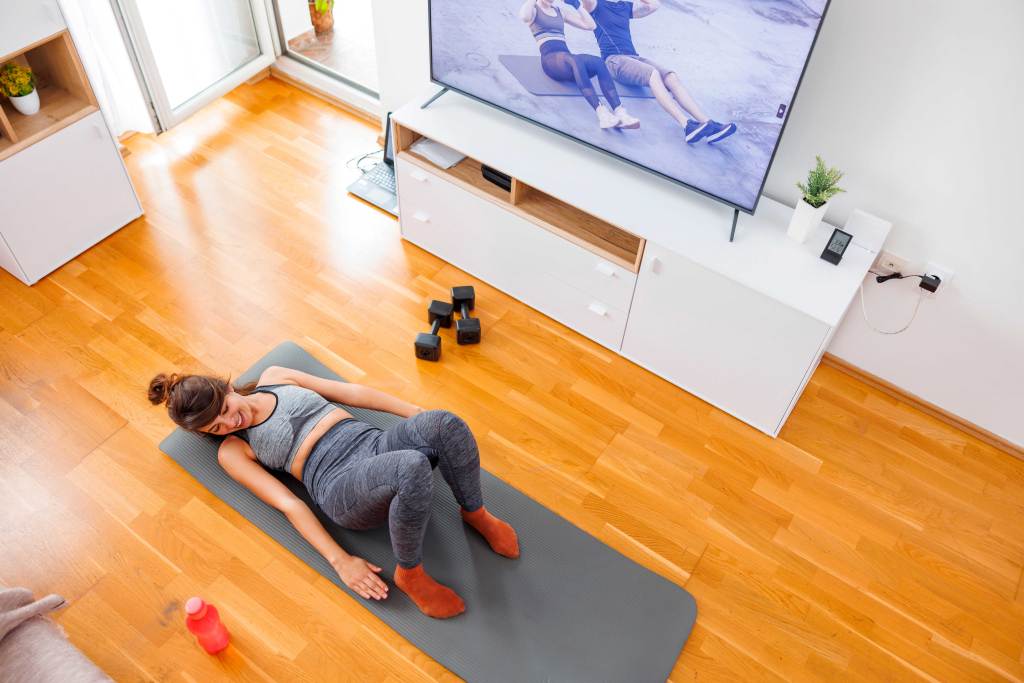 Frau macht beim Homeworkout Side-Crunches