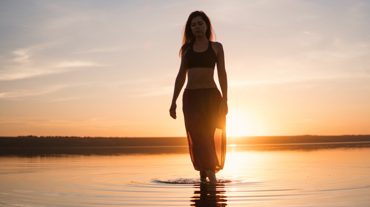 Frau am Strand, bei Sonnenuntergang