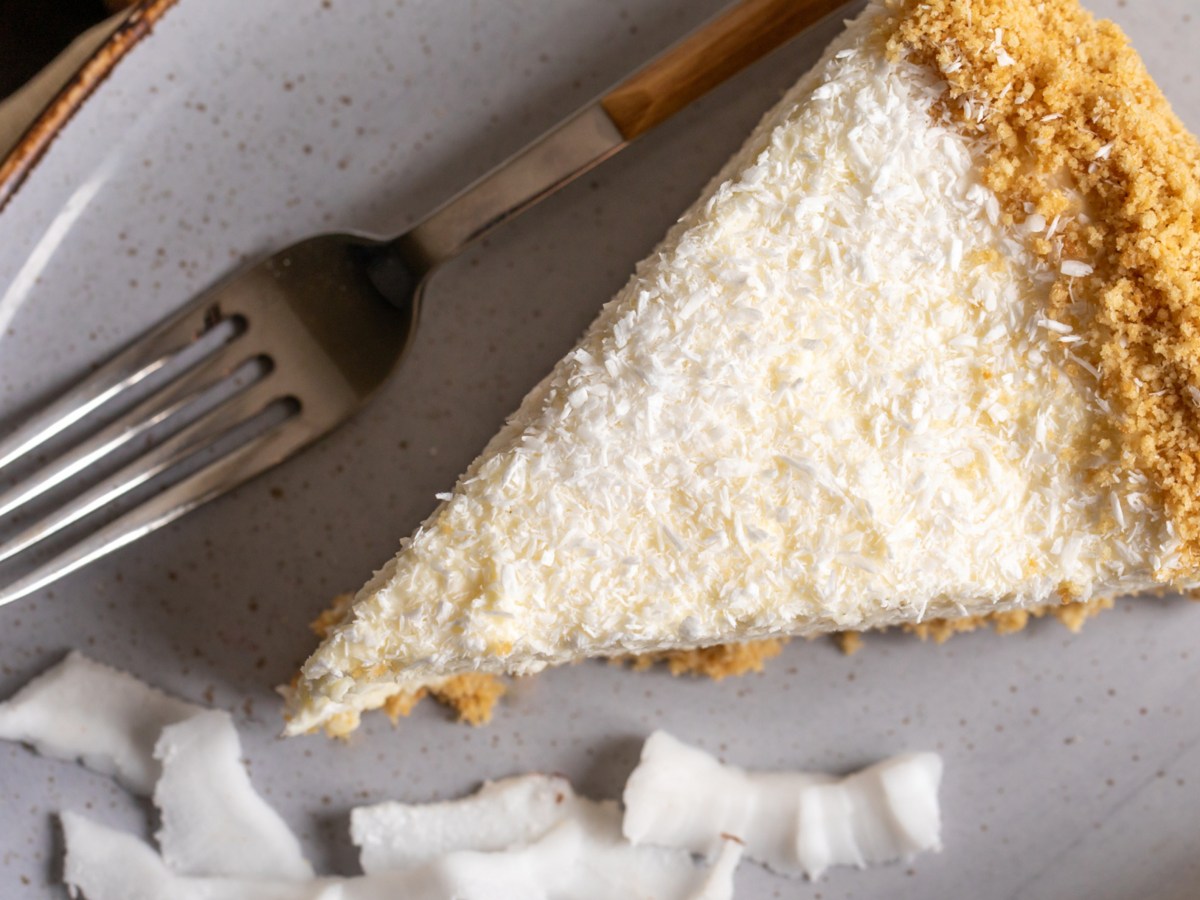 Käsekuchen mit Kokosraspeln auf einem Teller.