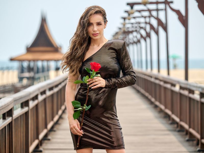 Jennifer Saro am Strand mit einer Rose in der Hand.