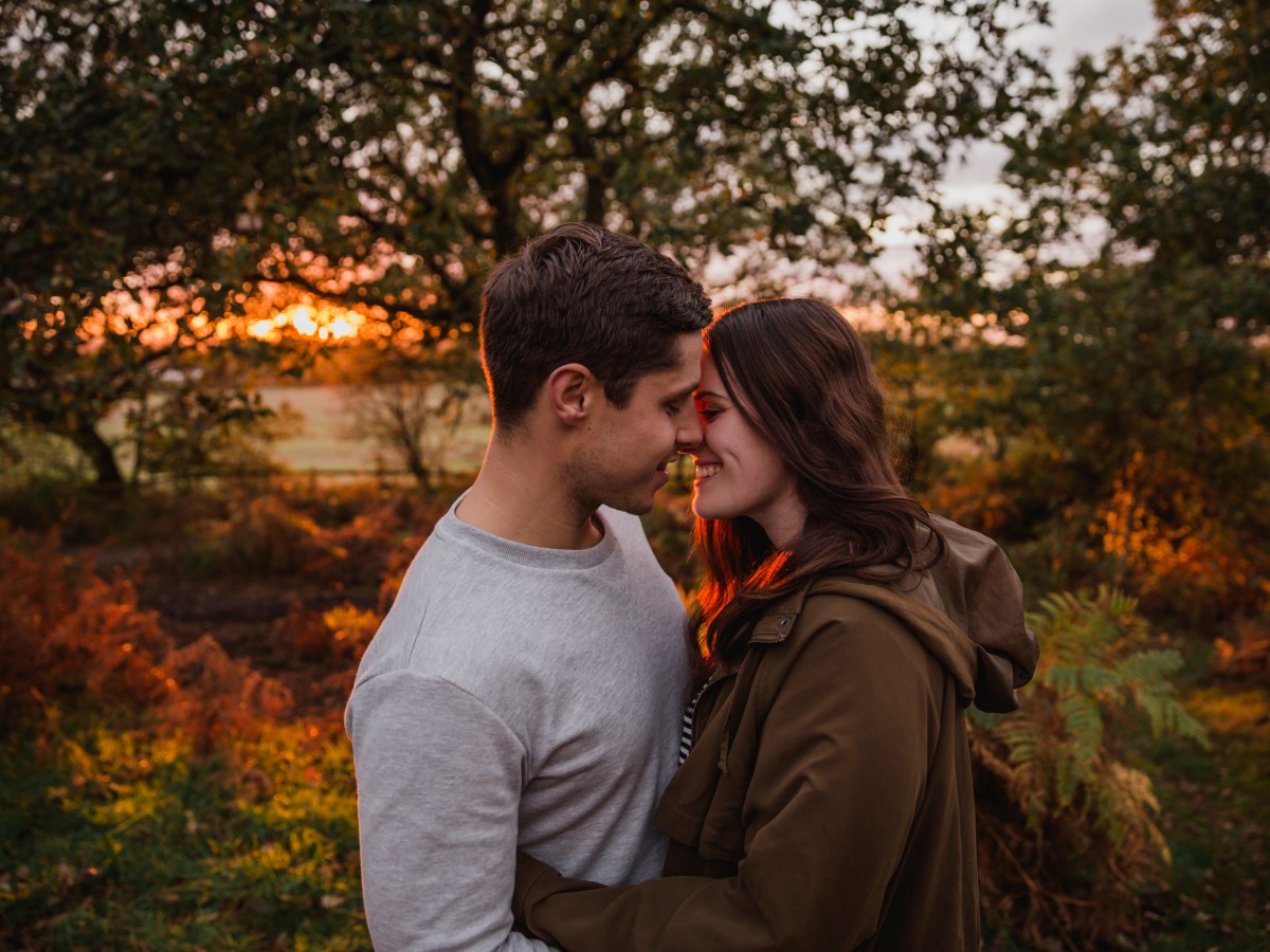 Paar k&uuml;sst sich verliebt vor Waldhintergrund