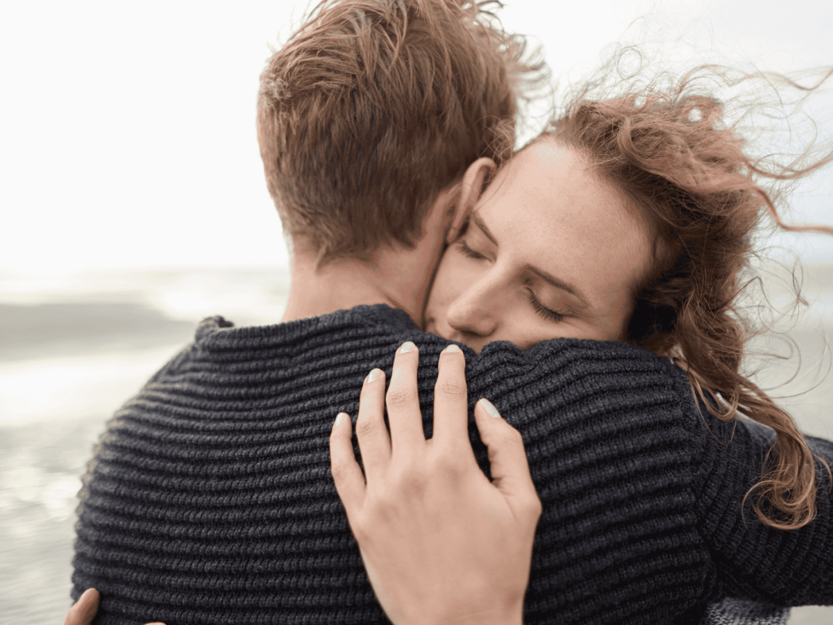 Ein Paar umarmt sich verliebt am Meer