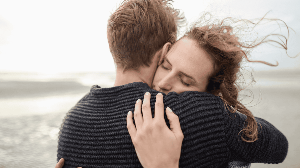 Ein Paar umarmt sich verliebt am Meer
