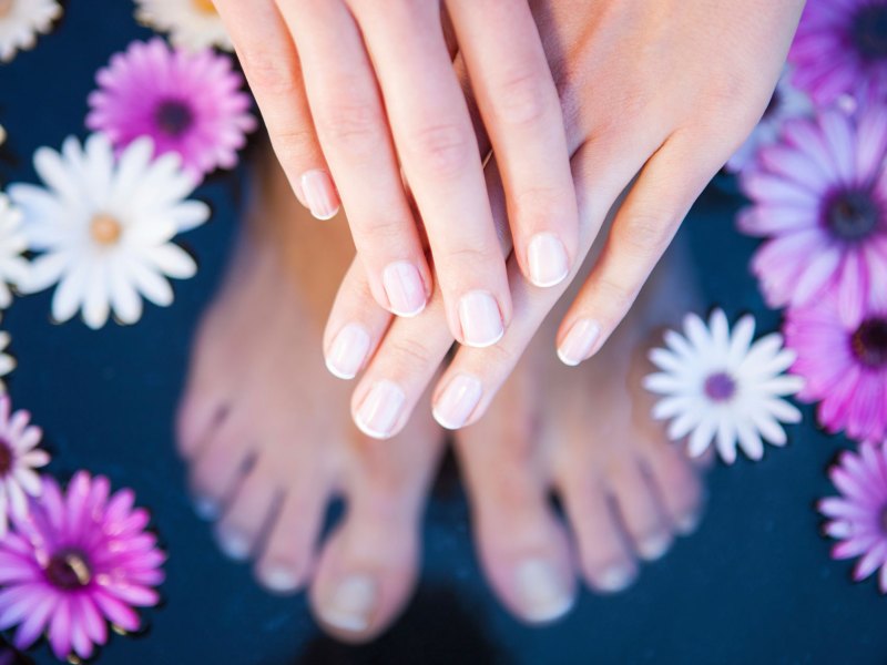 Gepflegte H&auml;nde und F&uuml;&szlig;e in einem Wasserbad.