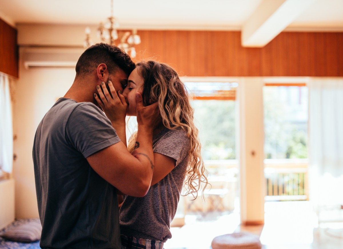 Paar küsst sich verliebt in Wohnzimmer