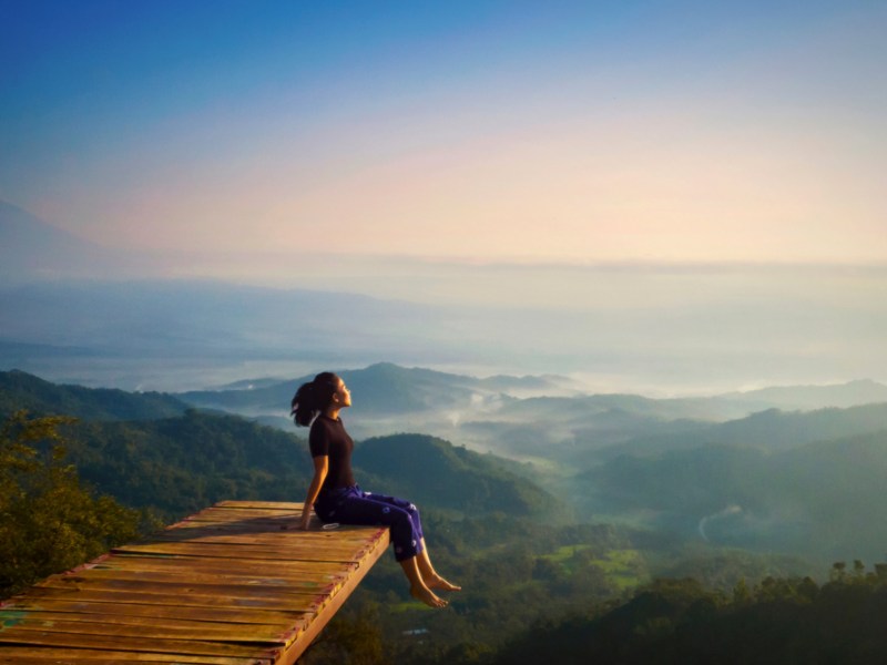 Frau auf Steg vor Landschaft