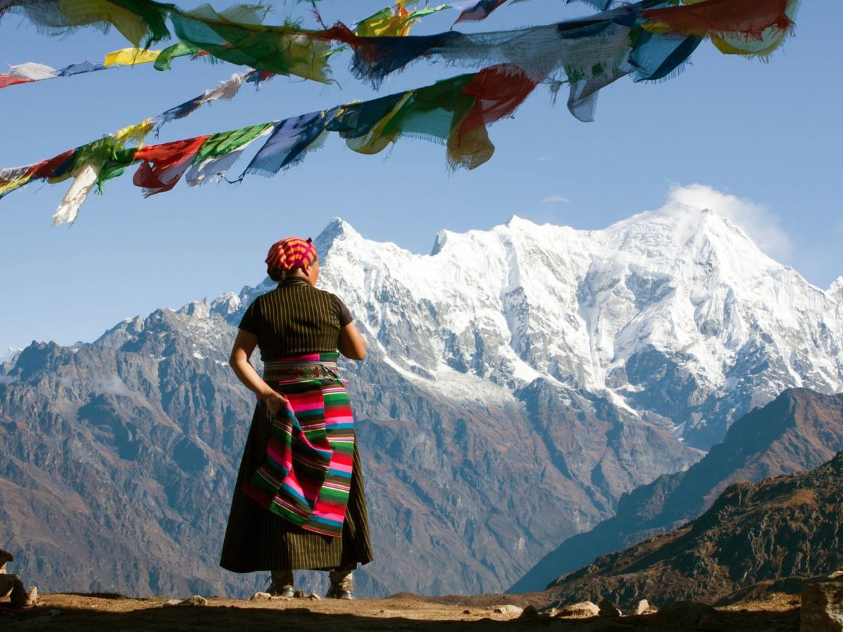 &Auml;ltere Frau aus Tibet schaut auf Berge.