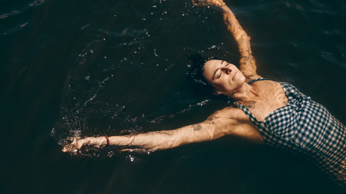 Frau liegt in Wasser.