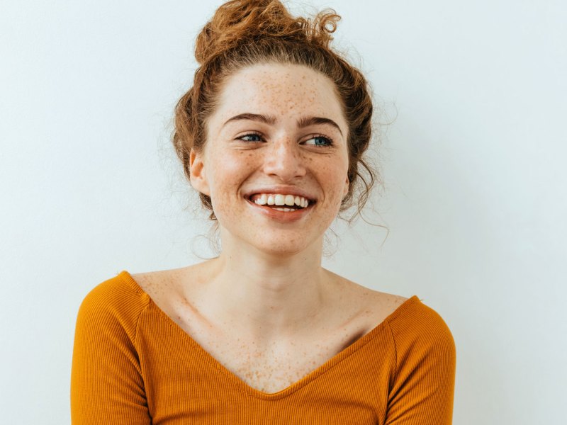 Frau mit rotem Haar und sympathischen Lachen