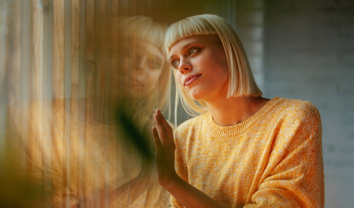 Junge Frau schaut aus dem Fenster