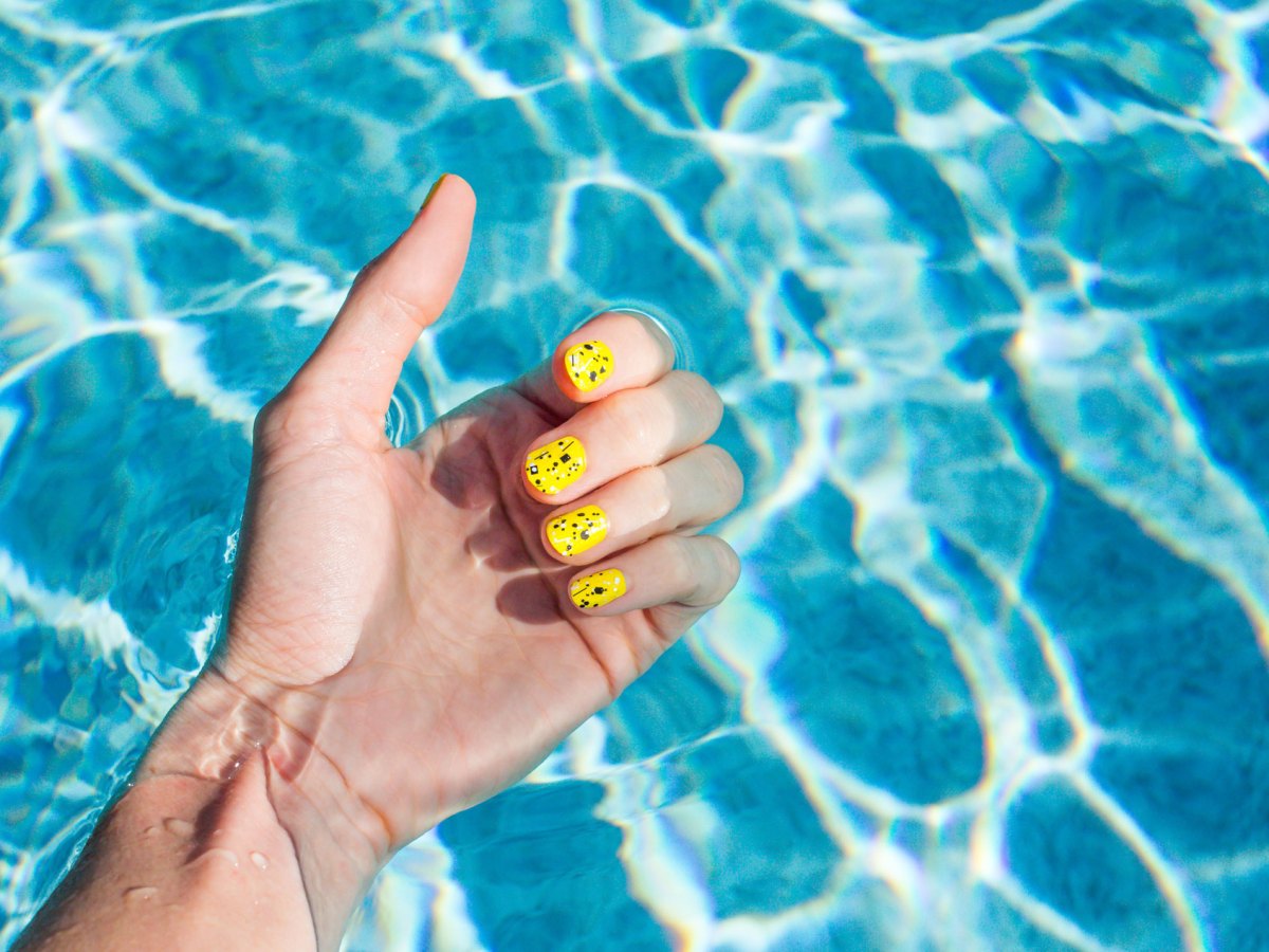 Frau mit lackierten N&auml;gel im blauen Pool.