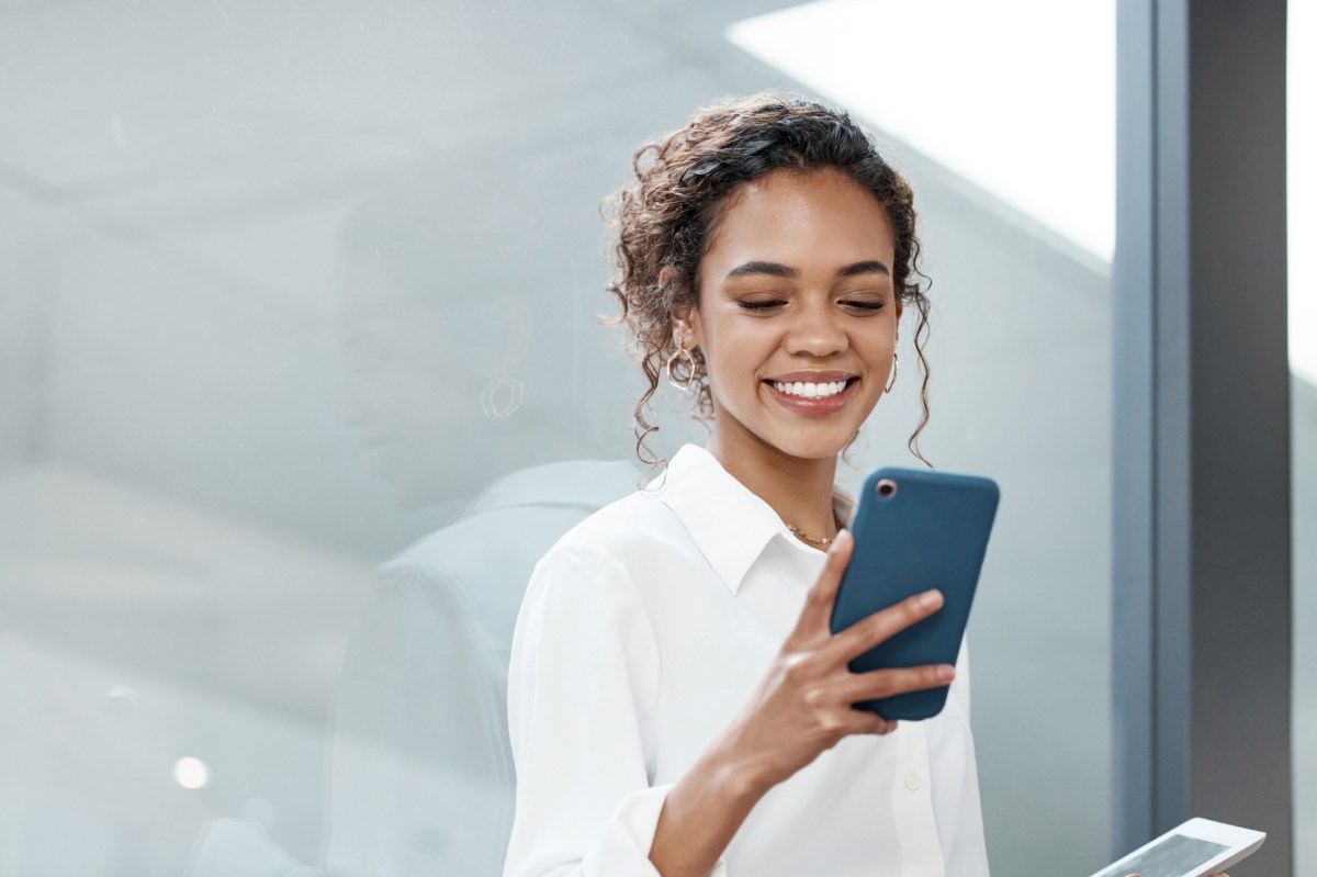 Frau hat ein Handy auf der Arbeit in der Hand.