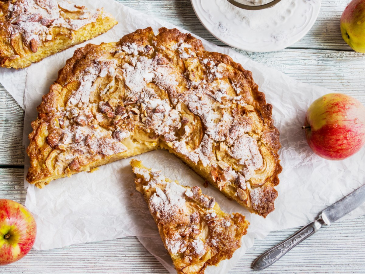 Apfelkuchen mit Mandeln auf weißem Untergrund.