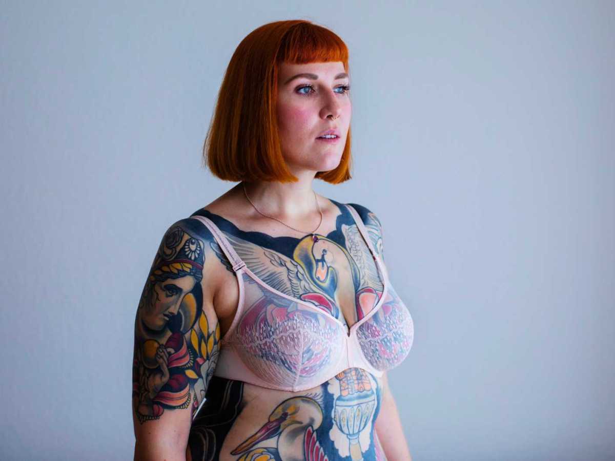 Rothaarige Frau mit Ganzk&ouml;rpertattoos.
