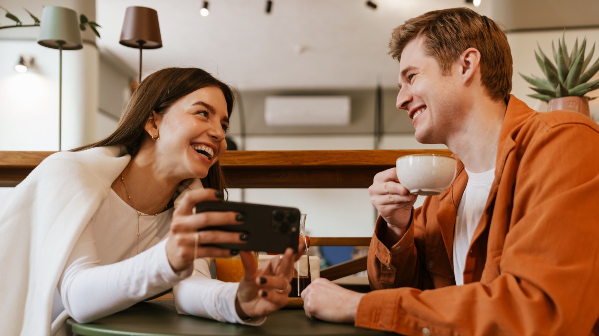 Mann und Frau im Café, die gemeinsam lachen