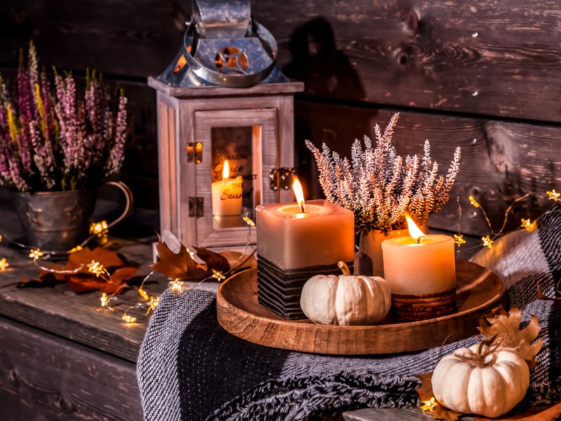 Herbstliche Deko bestehend aus einem Tablett mit Kerzen, Heidekraut und einer Laterne