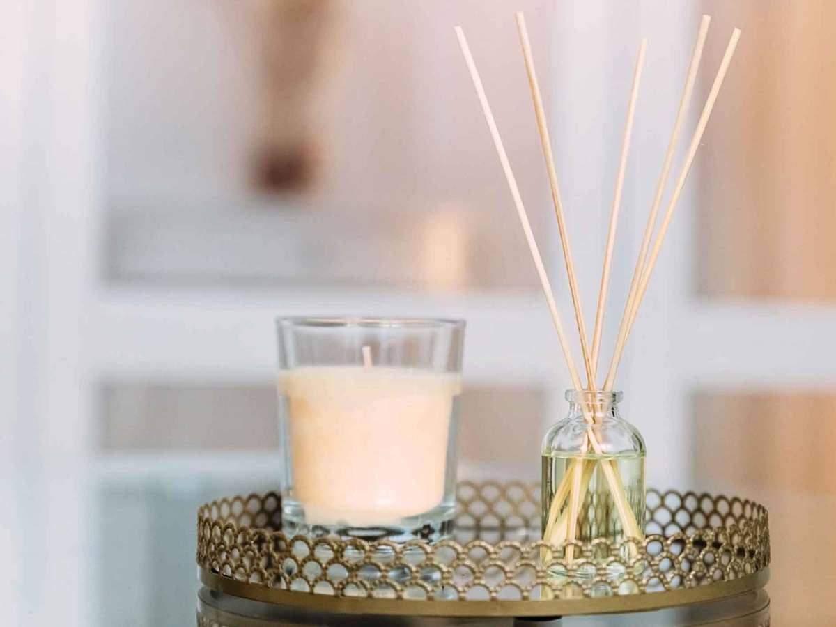 Kerze und Duftstäbchen auf einem Tablett.