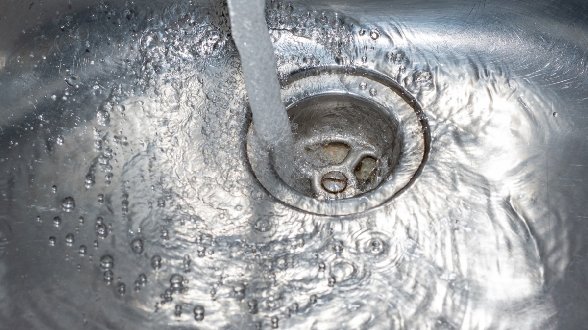 Wasser läuft einen Abfluss herunter.