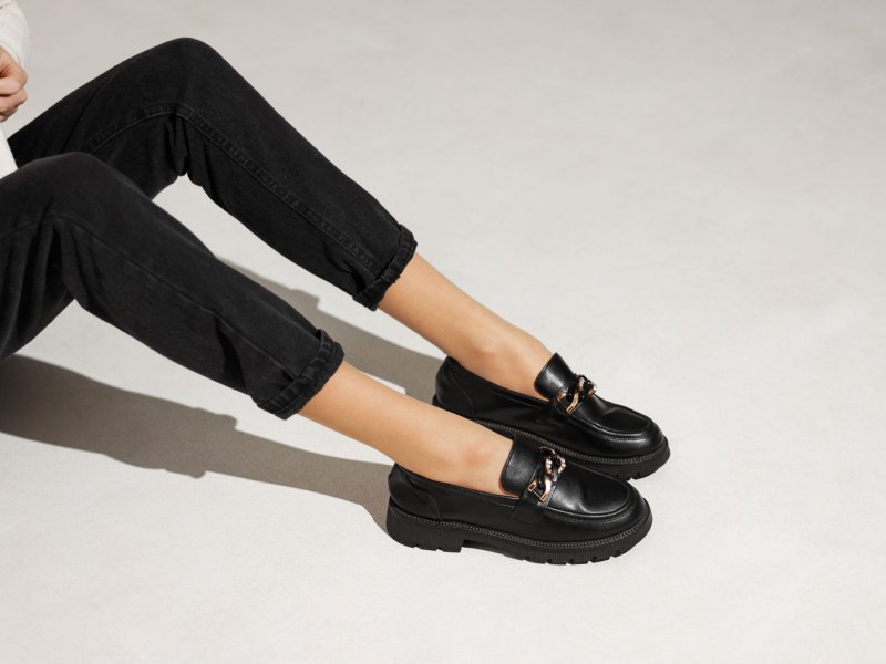 Frauenbeine in schwarzen Loafer