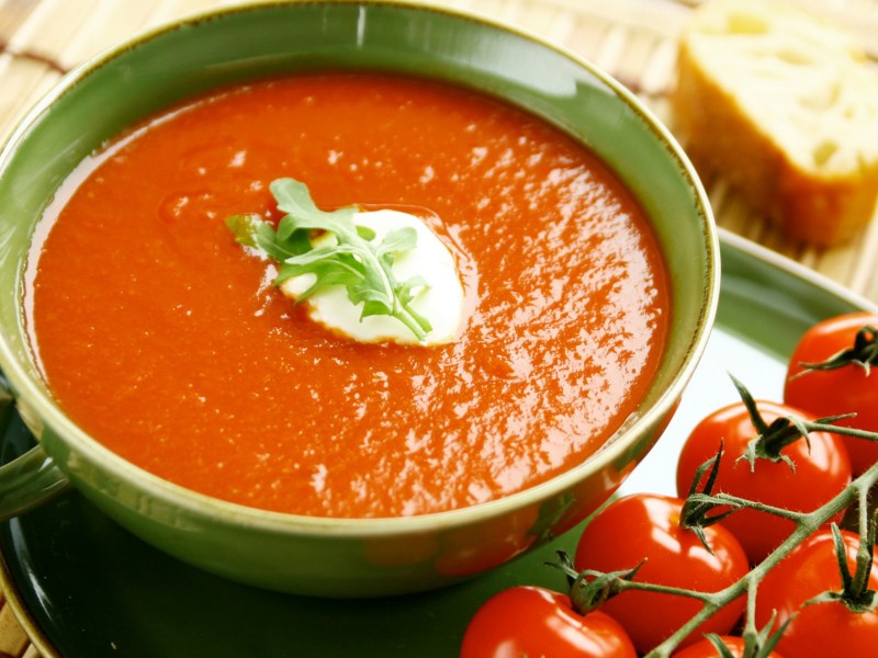 Tomatensuppe in einer grünen Suppenschüssel.