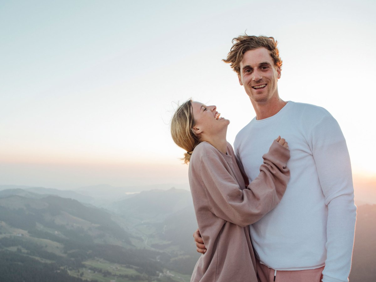 Ein Paar steht auf einer Anh&ouml;he und lacht