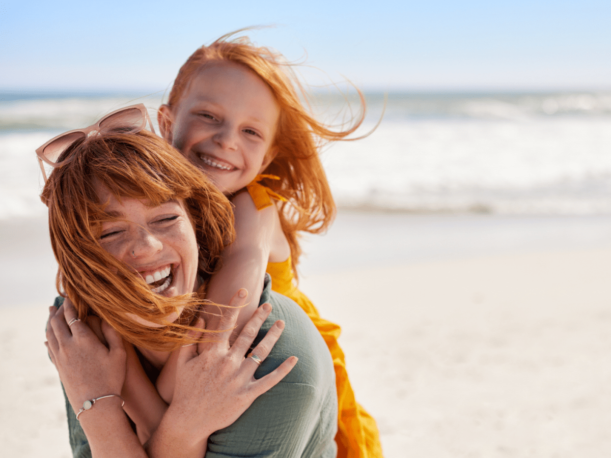 Mutter hebt Tochter auf dem Rücken und laufen am Strad herum