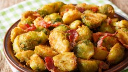 Rosenkohl mit Semmelbroesel auf braunem Teller.