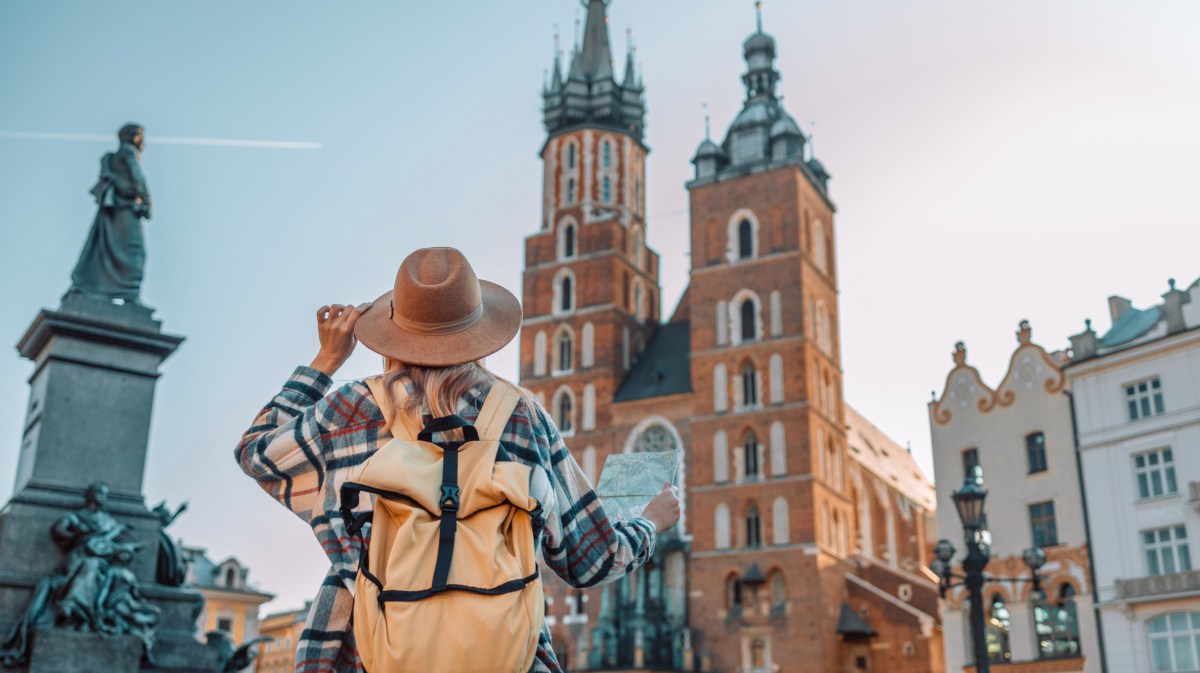 Frau mit Landkarte und Rucksack auf einem Städtetrip