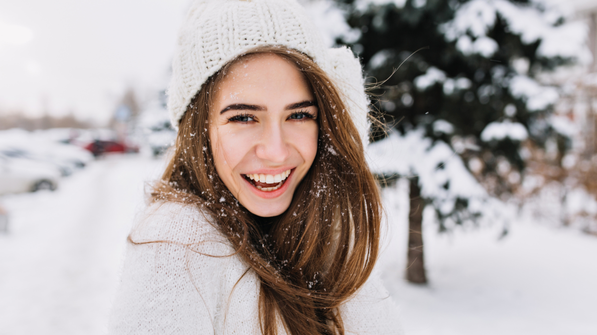 Frau im Schnee, die glücklich zur Seite schaut