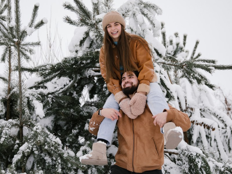 Pärchen im Schnee, das gemeinsam in die Kamera lacht