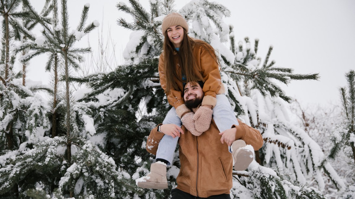 Pärchen im Schnee, das gemeinsam in die Kamera lacht