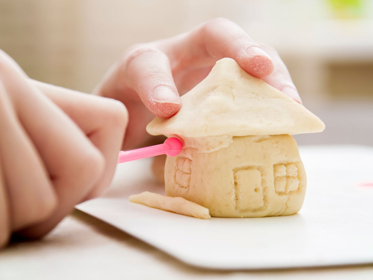 Salzteig-Rezept: Kinderhand formt H&auml;uschen aus Salzteig