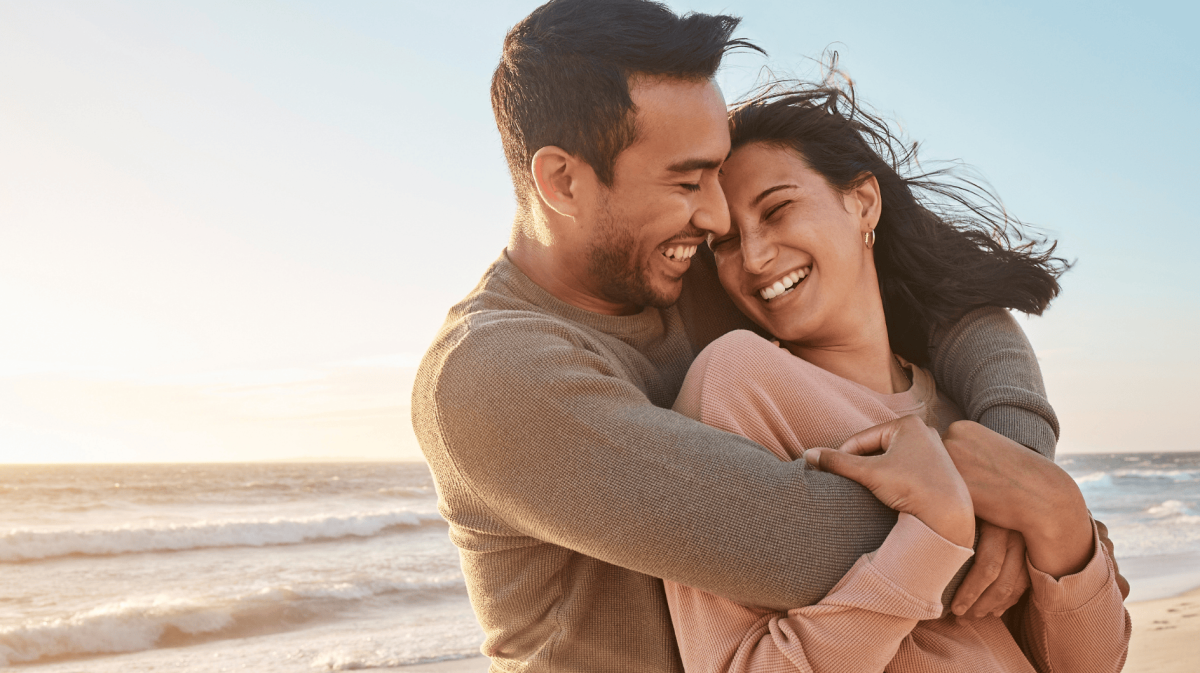 Glückliches Paar umarmt sich am Strand.