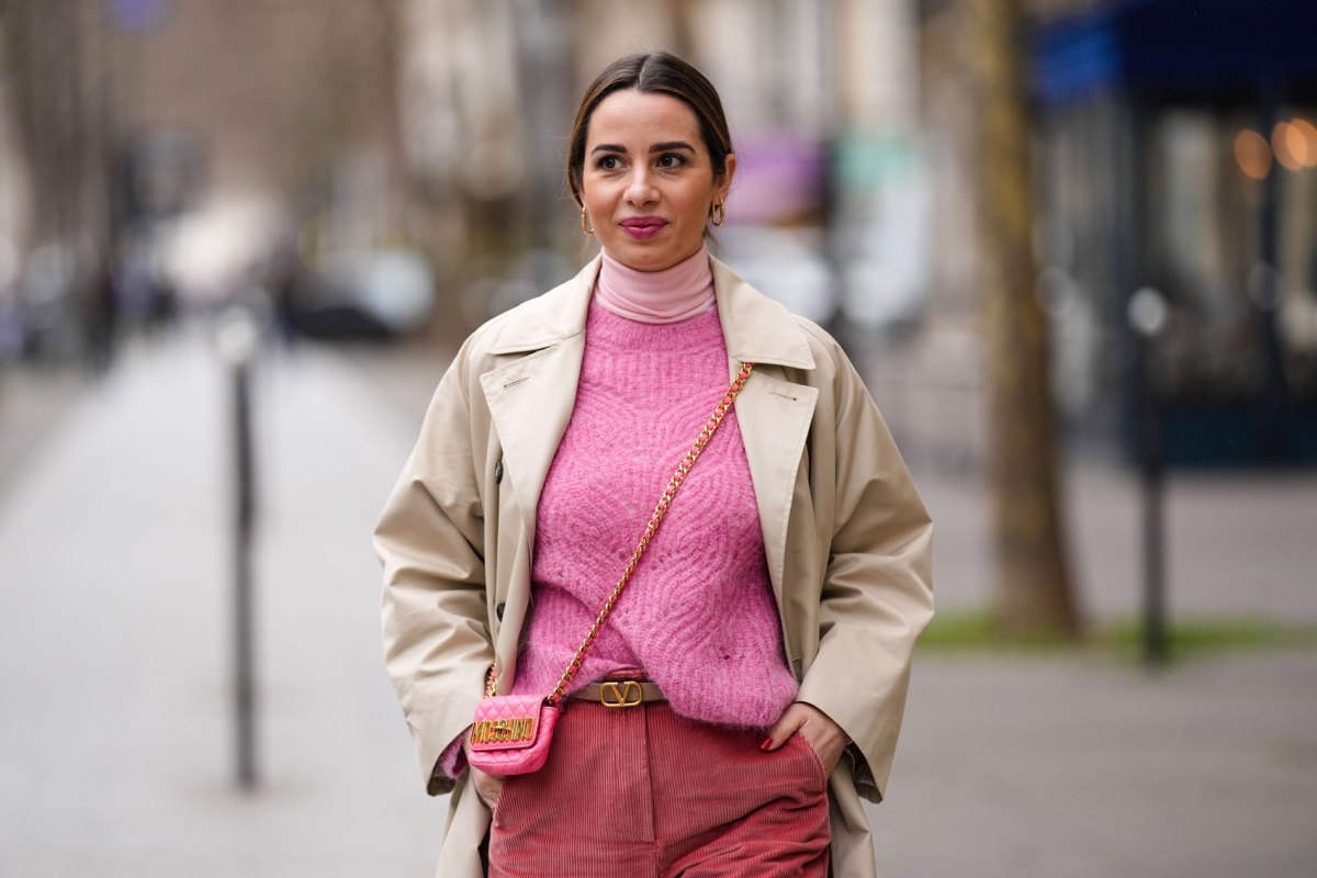 Frau mit rosa Pullover und einem Trenchcoat-Mantel