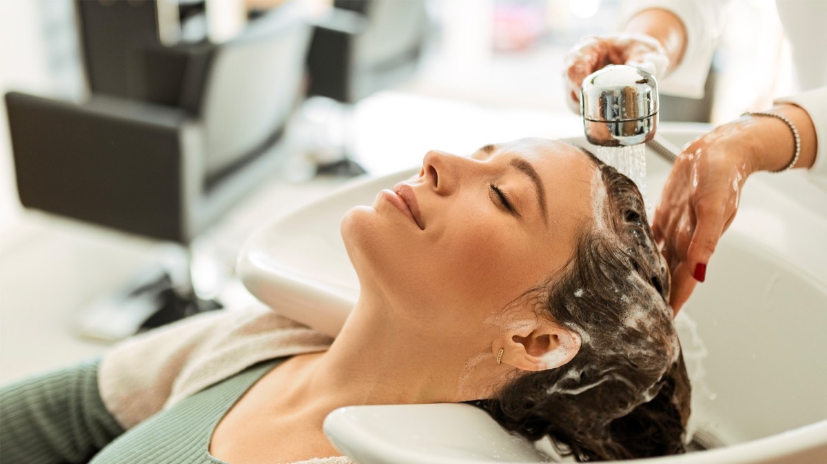 Frau, die im Haarsalon die Haare gewaschen bekommt.