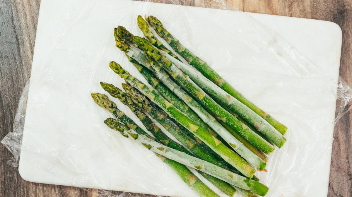 Gefrorene Spargelstangen liegen auf einem Küchenkrepp.