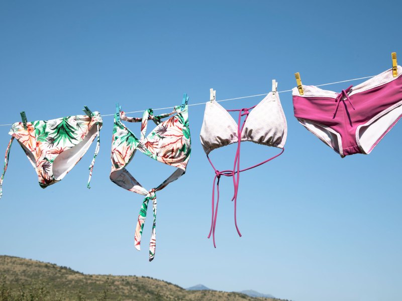 Bikinis, die in der Sonne auf einer W&auml;scheleine trocknen und deren Farben sehr verblasst sind.