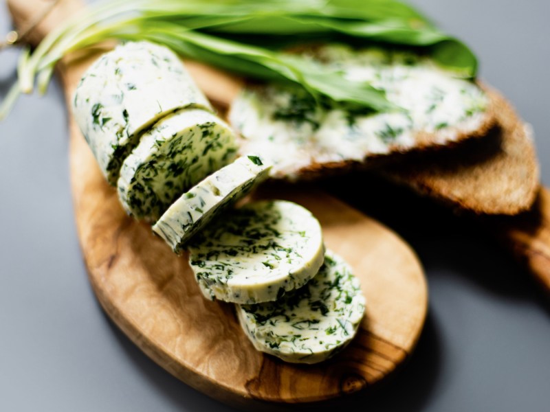 Bärlauch-Butter auf einem Holzbrett.