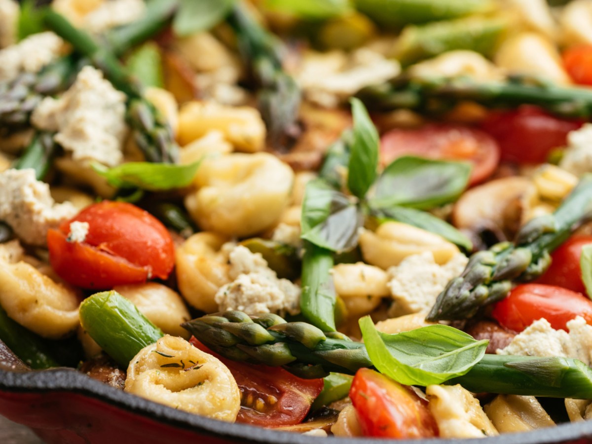 Nudelsalat mit Tortellini, grünem Spargel, Tomaten und Basilikum.