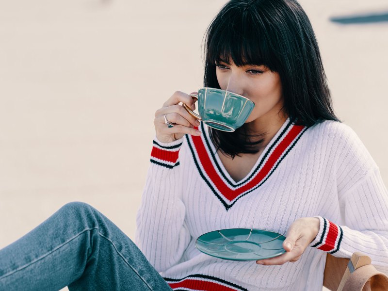 Frau mit dunklen Haaren trinkt Kaffee