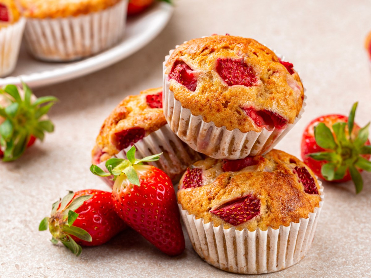 Mehrere Erdbeer-Muffins auf einem weißen Tisch.