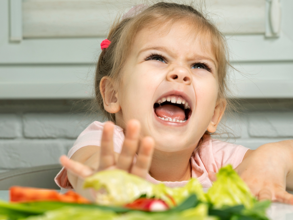 Kleines M&auml;dchen schiebt ihren Gem&uuml;se-Teller von sich weg