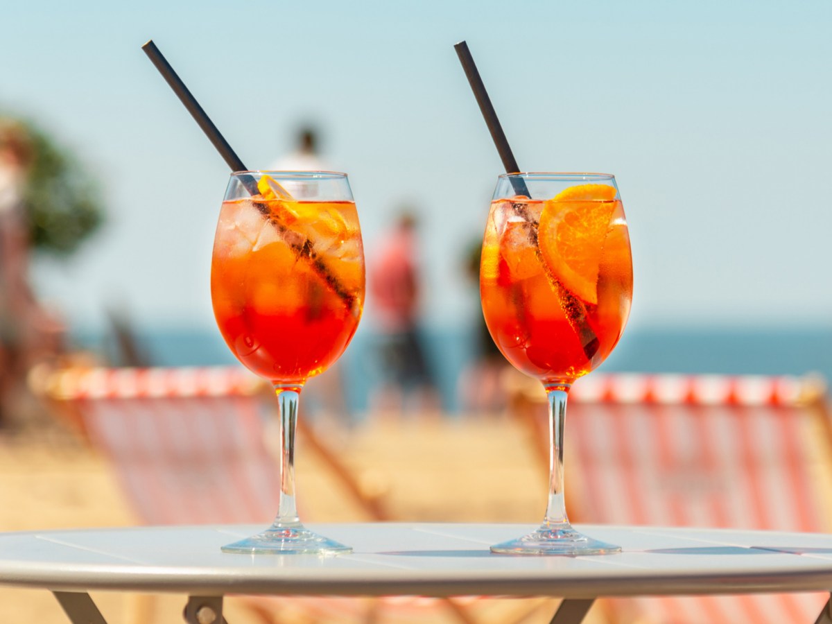 Zwei Cocktailgl&auml;ser auf Tisch vor sommerlichem Hintergrund.