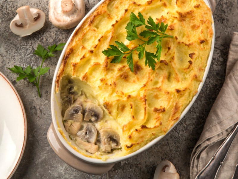 Shepherd's Pie mit Hähnchen und Pilze-Füllung in weißer Auflaufform.