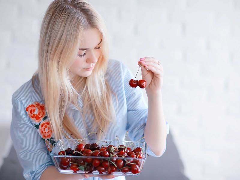 s&uuml;&szlig;es M&auml;dchen isst Kirsche / Konzept gesunde Ern&auml;hrung